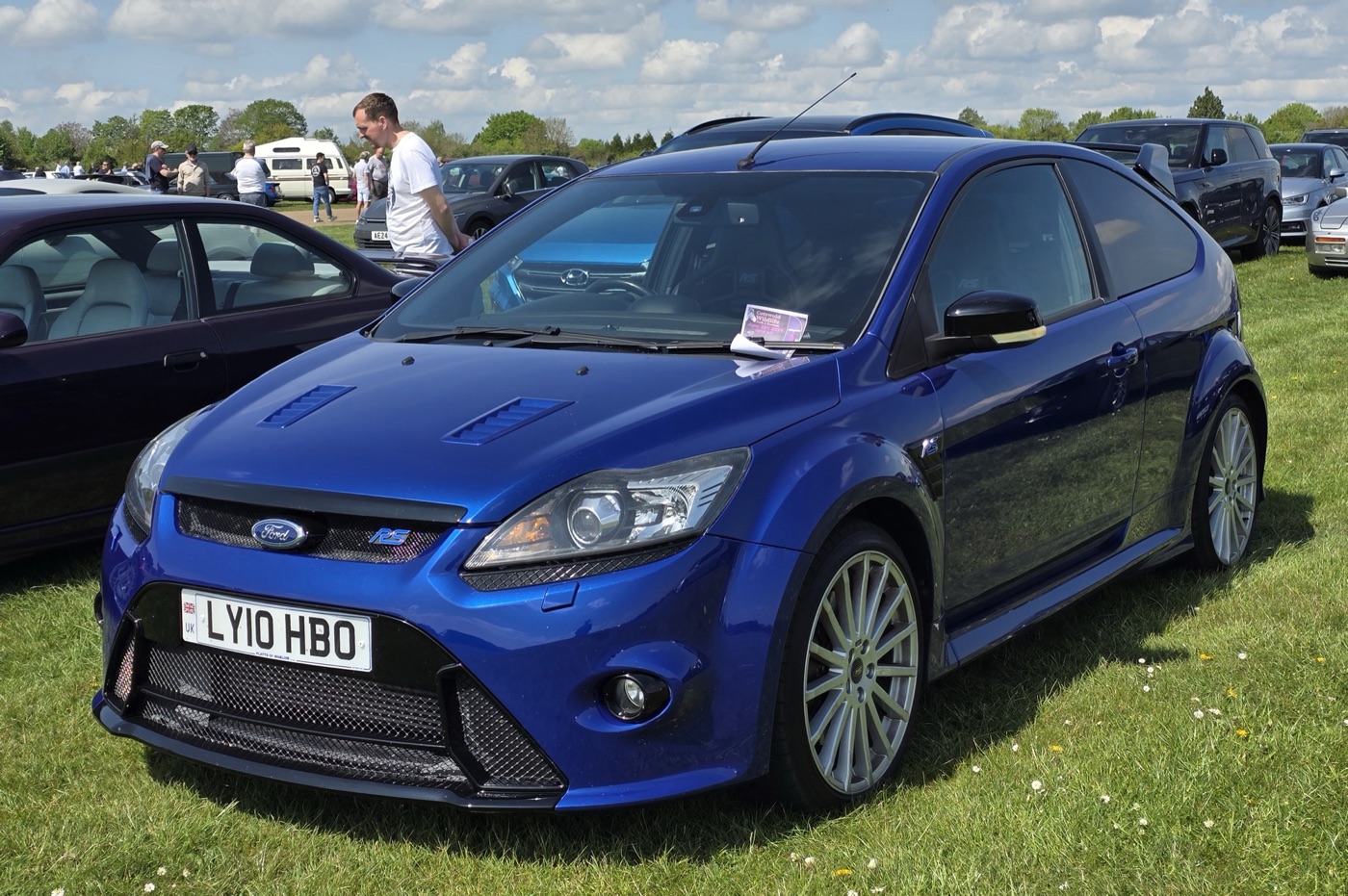 Performance Blue Mk2 Ford Focus RS with silver wheels parked on grass at a car show