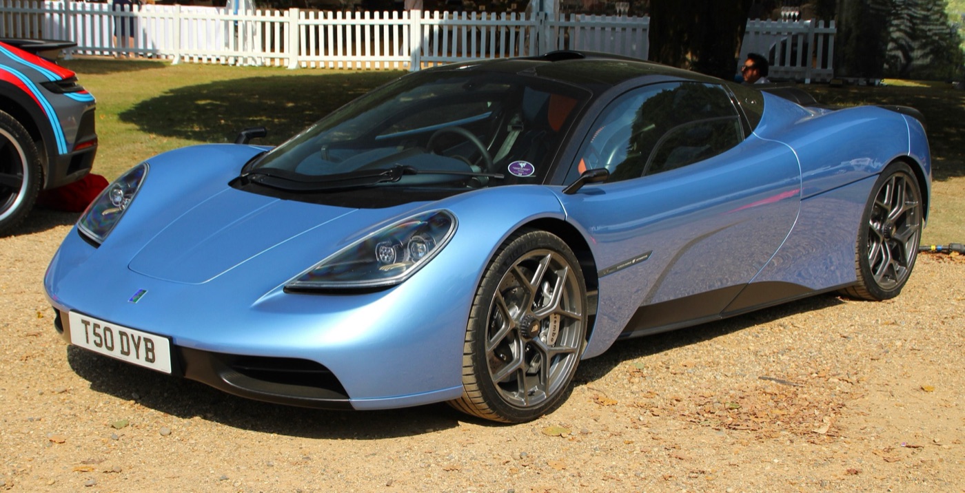 Pale blue Gordon Murray Automotive T.50 supercar with a black roof, registration T50 DYB, parked on gravel