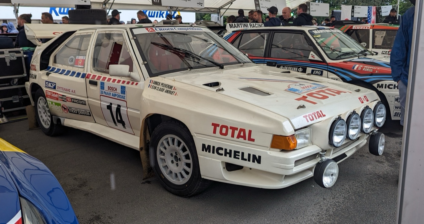 White Citroën BX 4TC rally car with Total and Michelin decals, number 14, and four spotlights, parked under a marquee