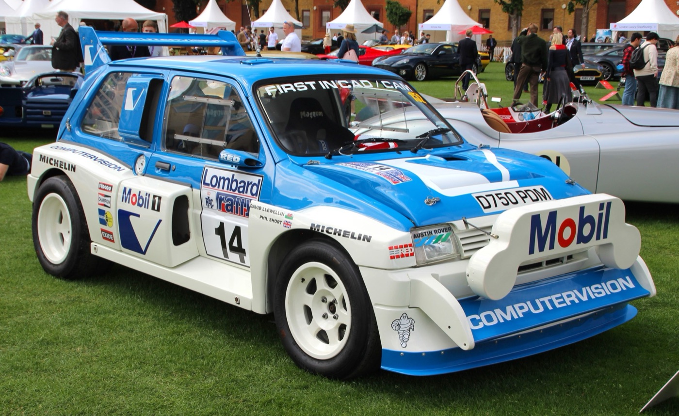 Blue and white MG Metro 6R4 rally car, number 14, with Computervision and Mobil decals and a large rear wing, parked on grass