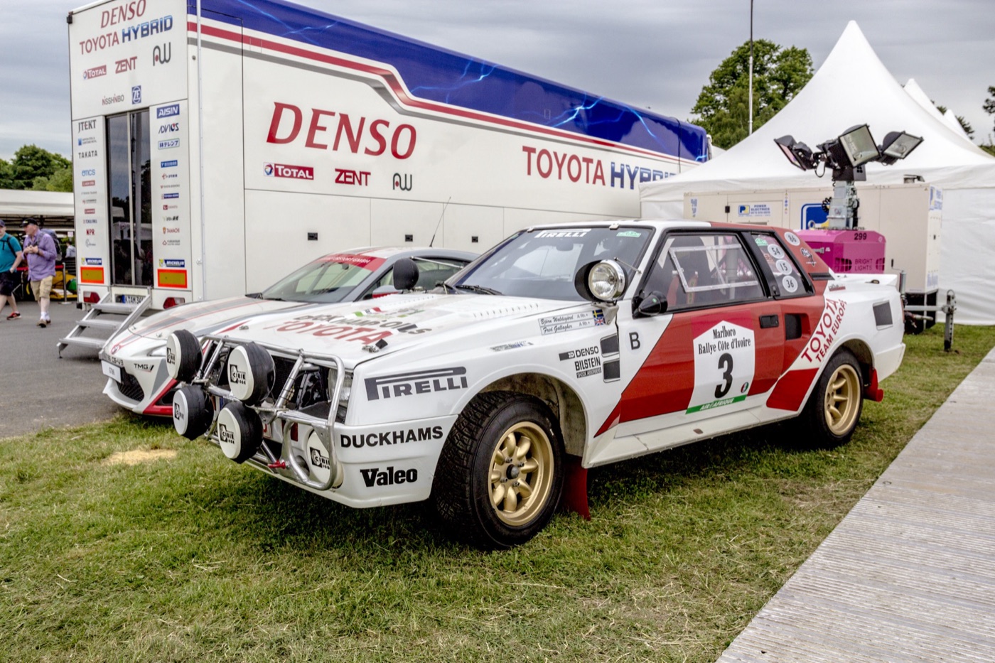 White and red Toyota Team Europe Celica Twin-Cam Turbo rally car, number 3, with a bull bar and four spotlights, parked on grass