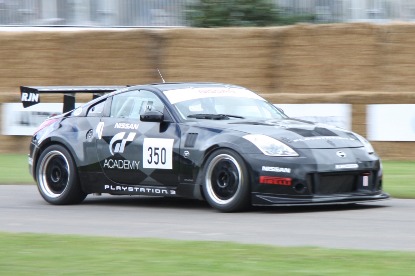 Black RJN Nissan 350Z race car in GT Academy and PlayStation 3 livery, number 350, on the hill climb with straw bales behind