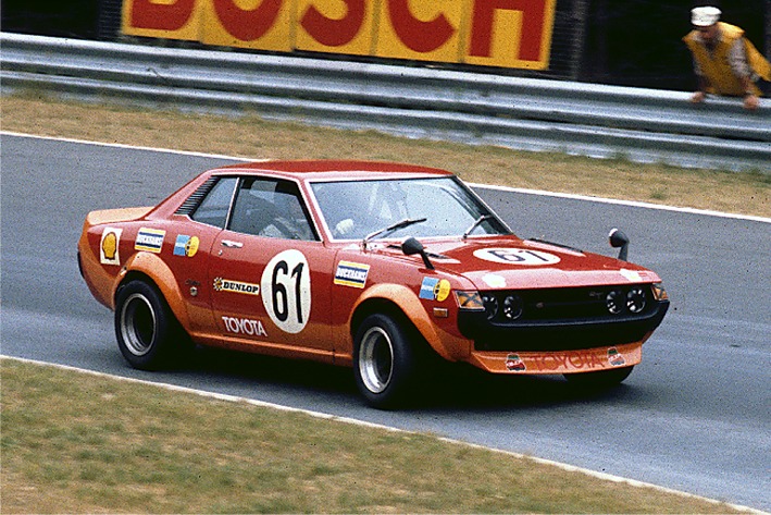 Orange and red Toyota Celica 1600GT race car number 61 cornering on a track in front of a Bosch advertising board