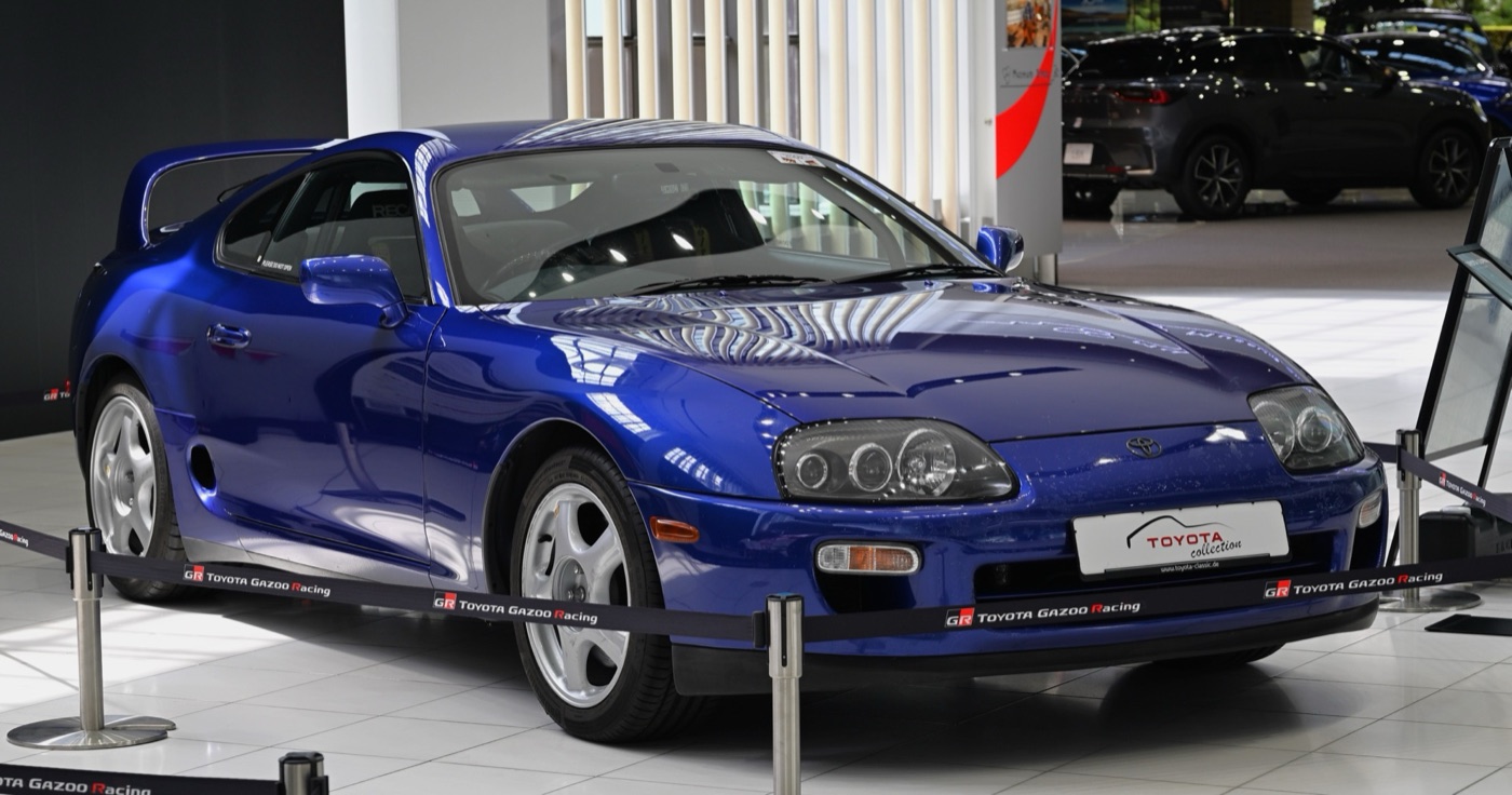 Blue fourth-generation Toyota Supra with Recaro seats on display behind Toyota Gazoo Racing barrier tape