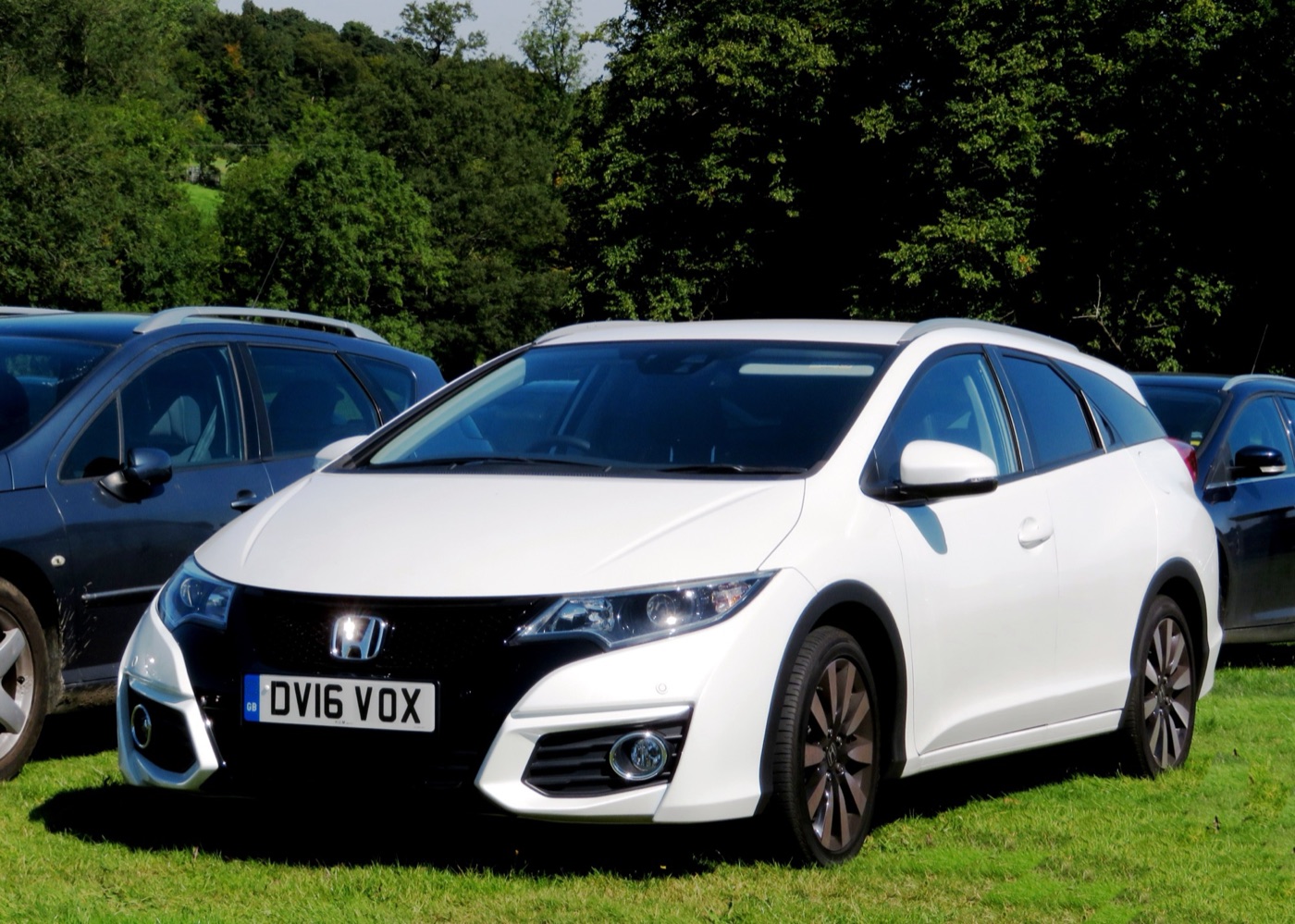 White facelifted Honda Civic Tourer estate with UK number plate parked on grass