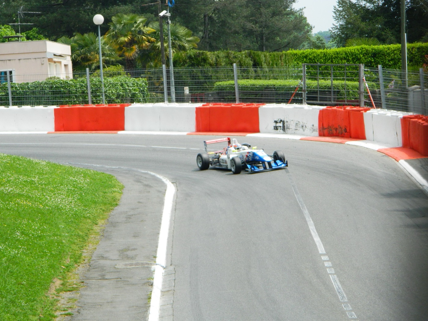 Jack Harvey’s white and blue Carlin Formula 3 car turning through a barrier-lined corner on the Pau street circuit