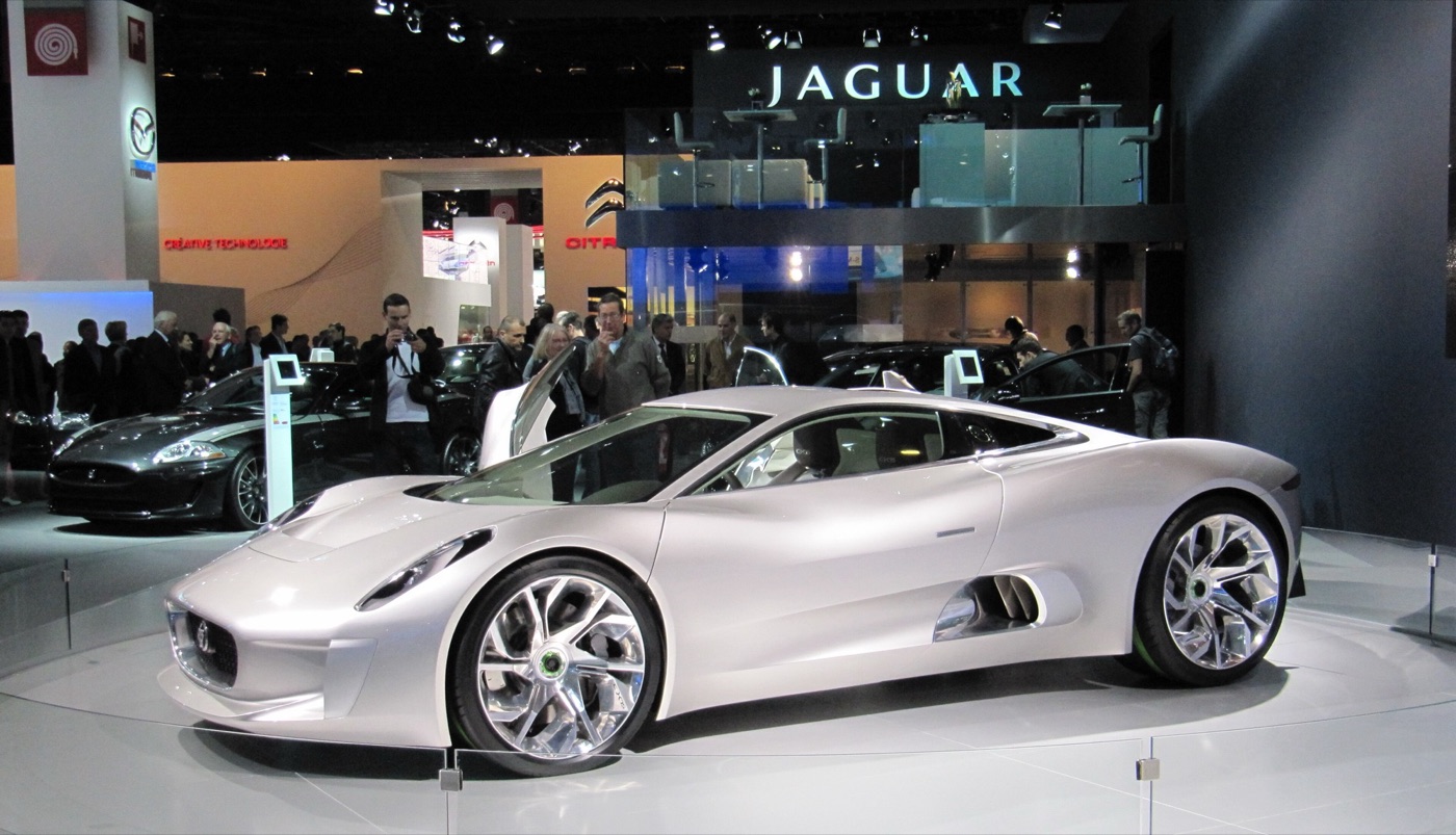 Silver Jaguar C-X75 concept on a turntable on the Jaguar stand at the 2010 Paris Motor Show, with visitors behind