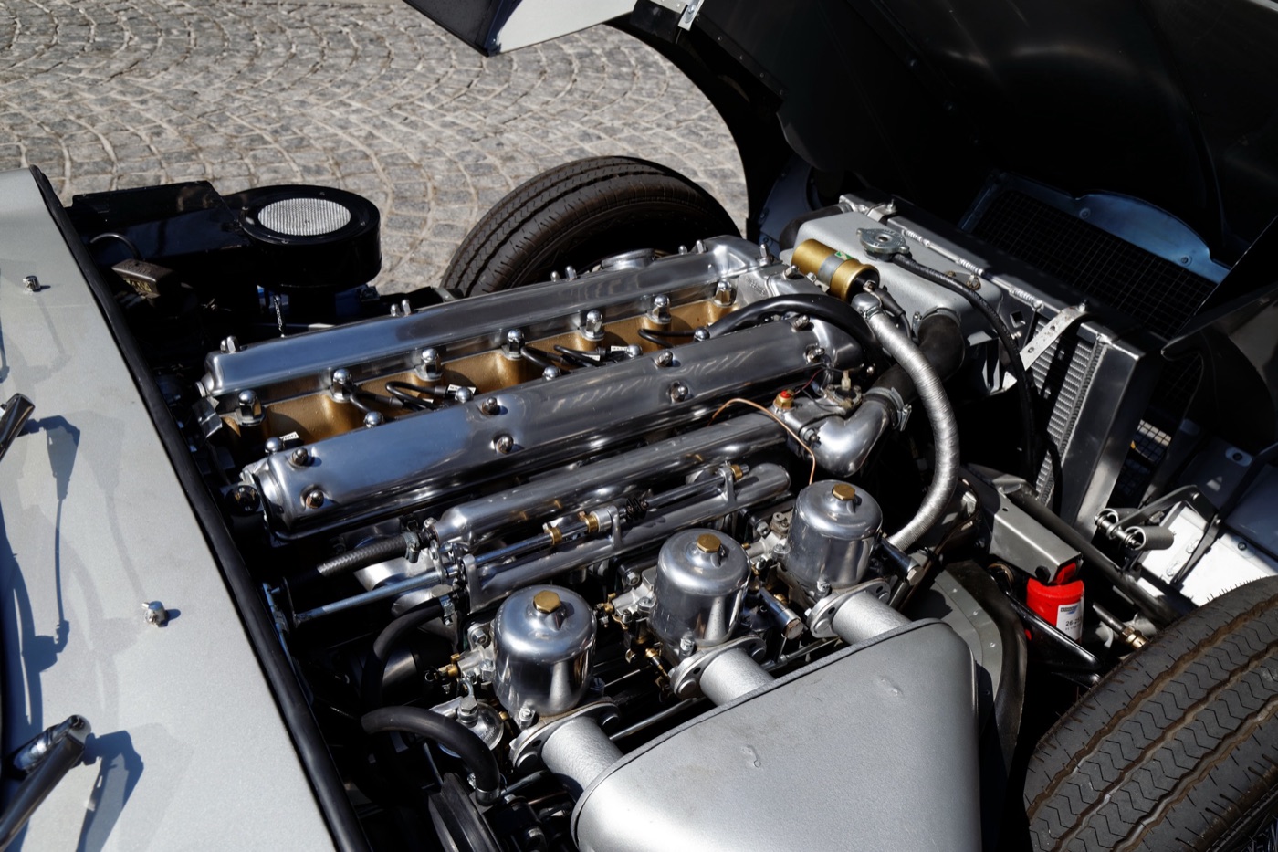 The 3.8-litre twin-cam XK straight six with polished cam covers and three SU carburettors in an E-Type engine bay