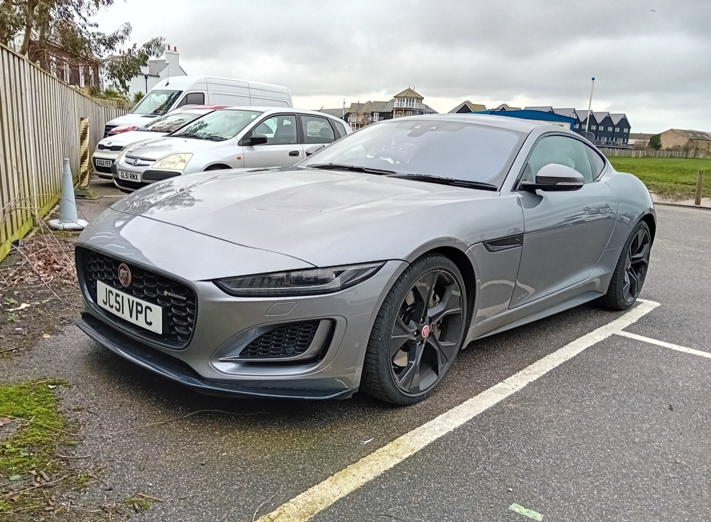 Grey facelifted 2020 Jaguar F-Type coupe with slim headlamps and black wheels in a car park