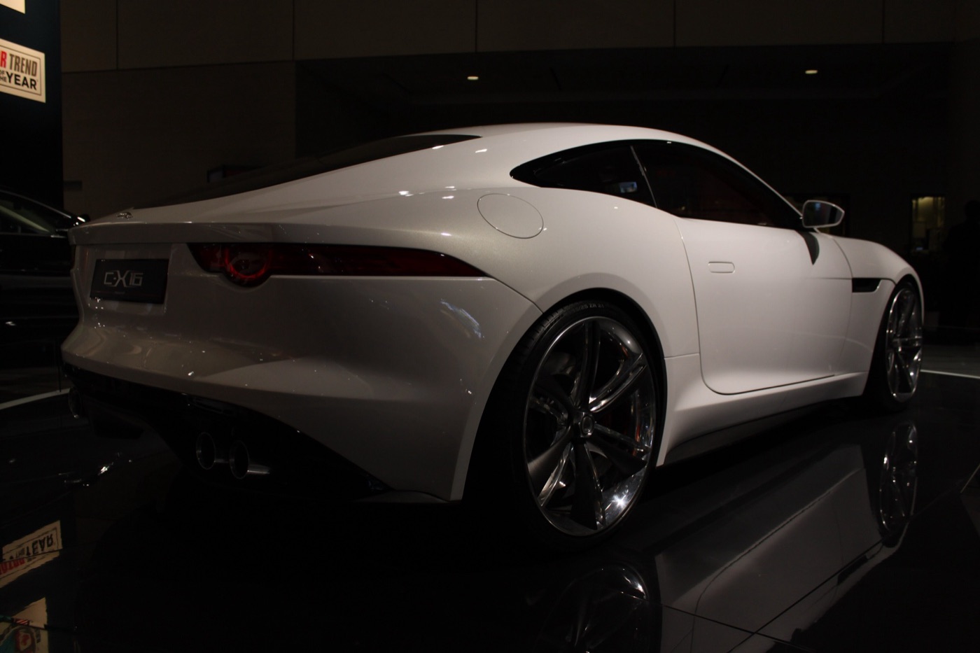 White Jaguar C-X16 concept coupe seen from the rear three-quarter on a dark motor show stand