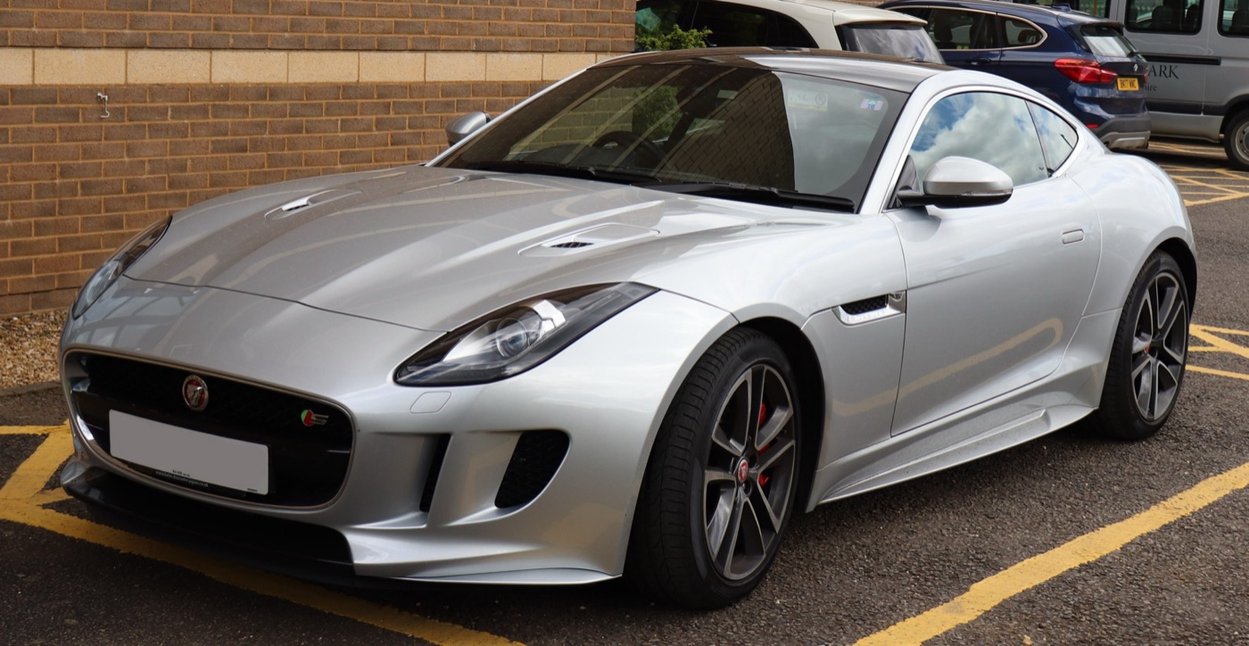 Silver 2015 Jaguar F-Type S coupe seen from the front three-quarter, showing its grille, bonnet vents and grey alloy wheels