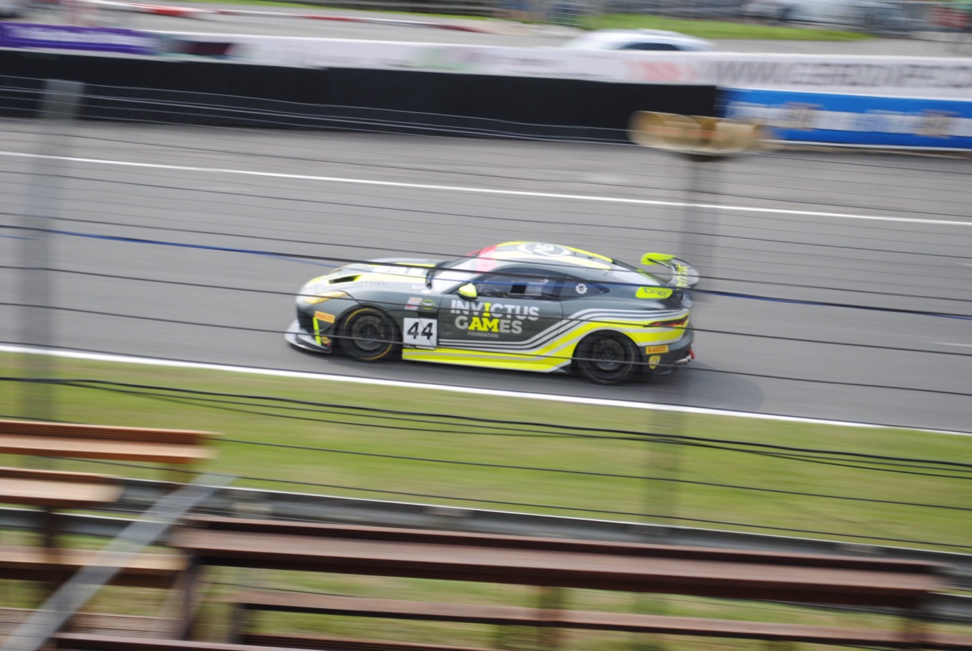 Grey and yellow Invictus Games Racing Jaguar F-Type SVR GT4 car number 44 on the pit straight, panned to blur the background
