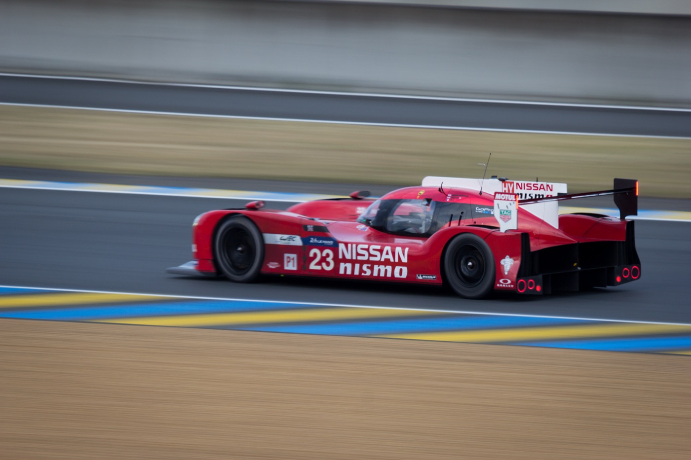 Red Nissan GT-R LM Nismo prototype number 23 at speed on the Le Mans circuit