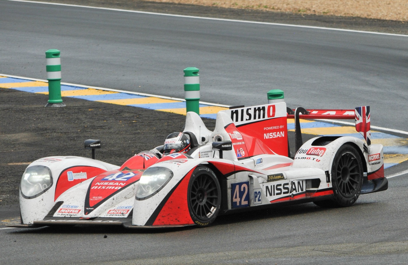 White and red Greaves Zytek-Nissan LMP2 prototype number 42 rounding a chicane at Le Mans, splashed with dirt