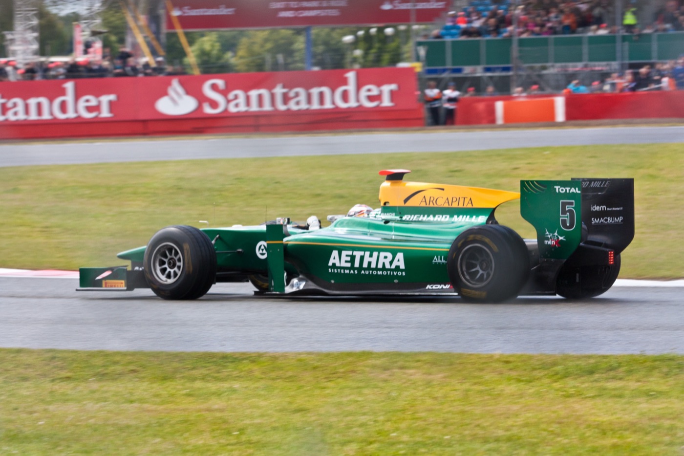 Green Lotus ART GP2 car number 5 on a damp track at Silverstone