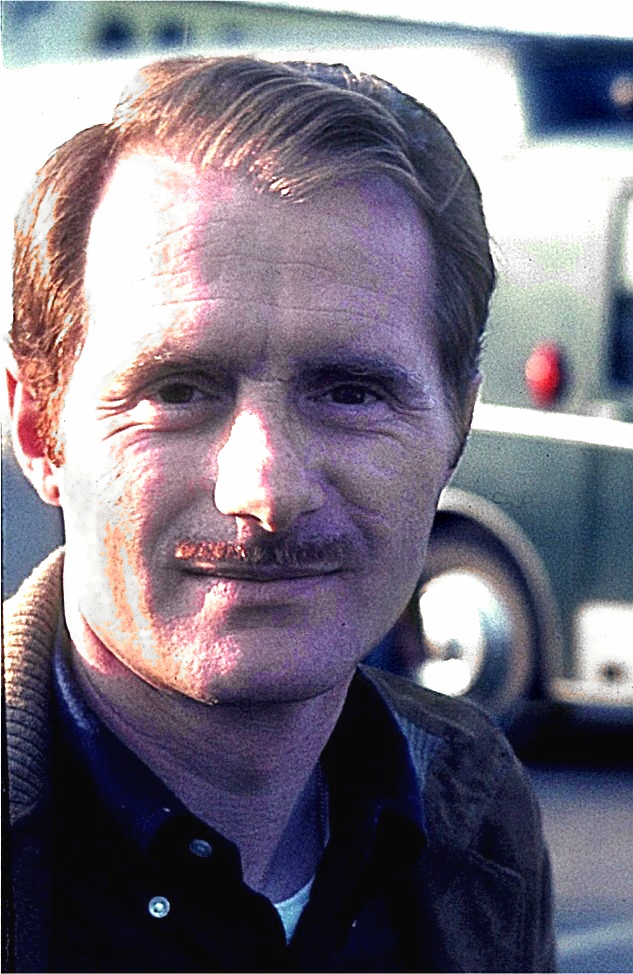 Head and shoulders portrait of Lucien Bianchi, with a moustache, in a paddock in 1968