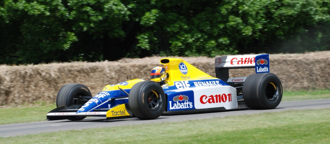 Blue, yellow and white Williams Renault Formula One car with Canon and Labatt’s sponsorship, on the Goodwood hill in front of straw bales