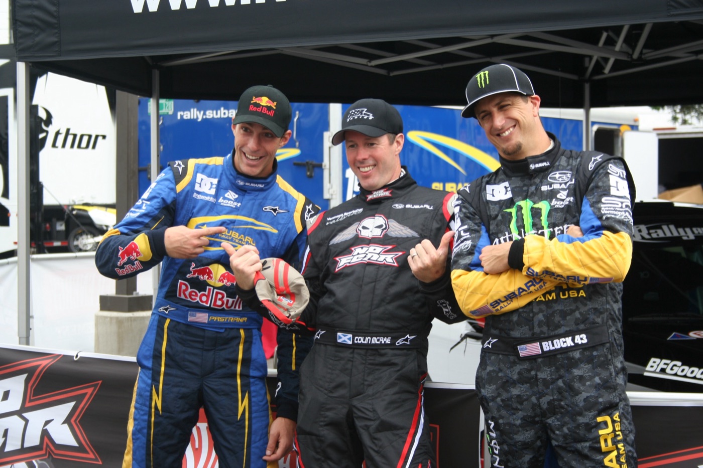 Travis Pastrana, Colin McRae and Ken Block standing together in their race suits