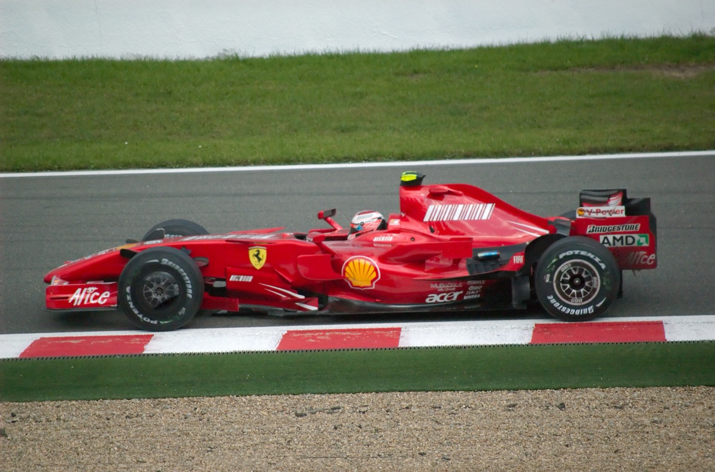 Red Ferrari F2007 with Shell and Alice sponsorship on track at Spa, the driver in a white and red helmet