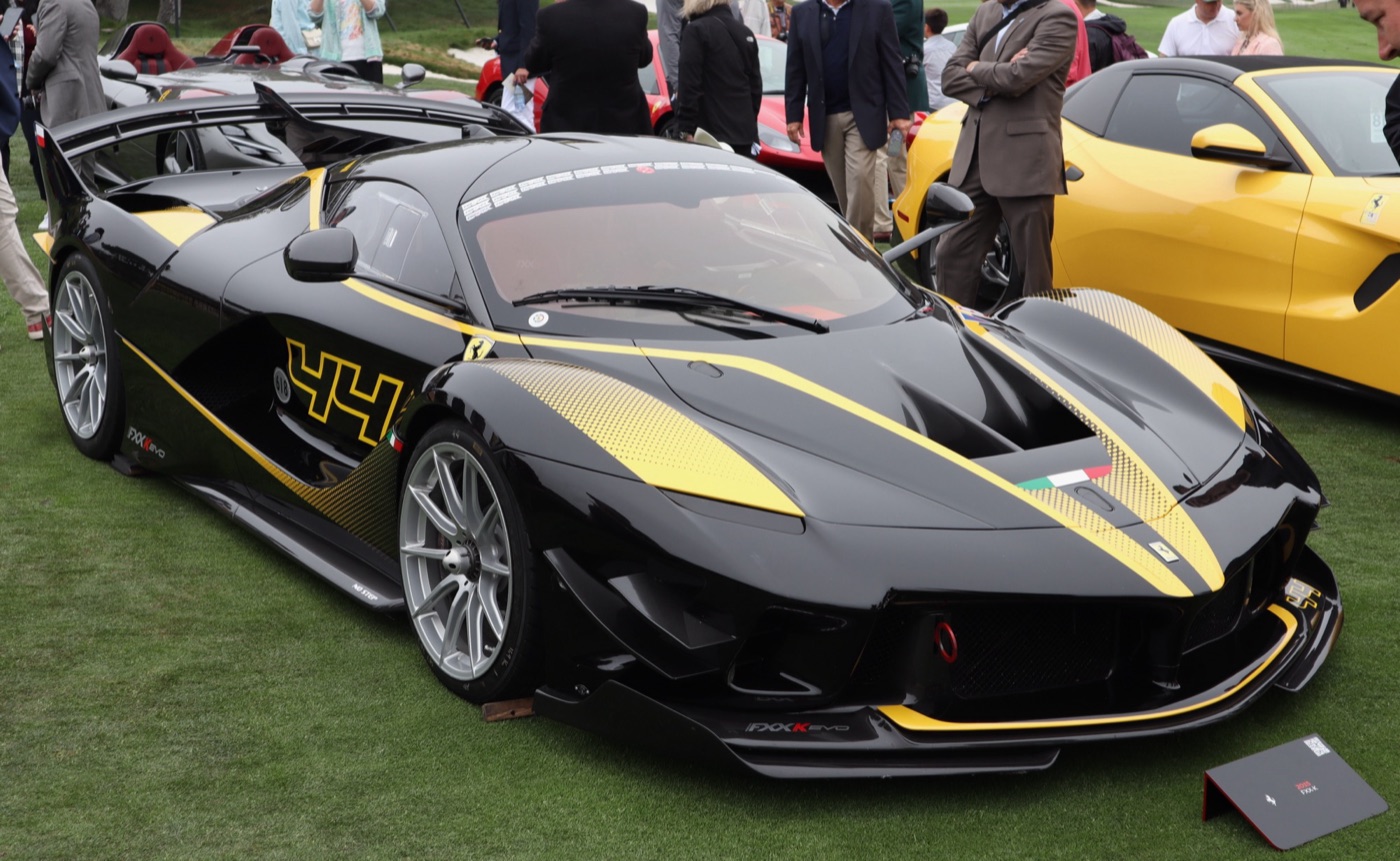 Black and yellow Ferrari FXX K Evo with the number 44 parked on the lawn at a concours