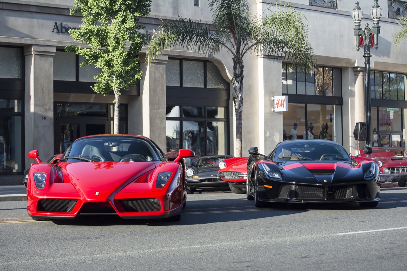 A red Ferrari Enzo and a black and red LaFerrari parked nose to camera on a street in Pasadena