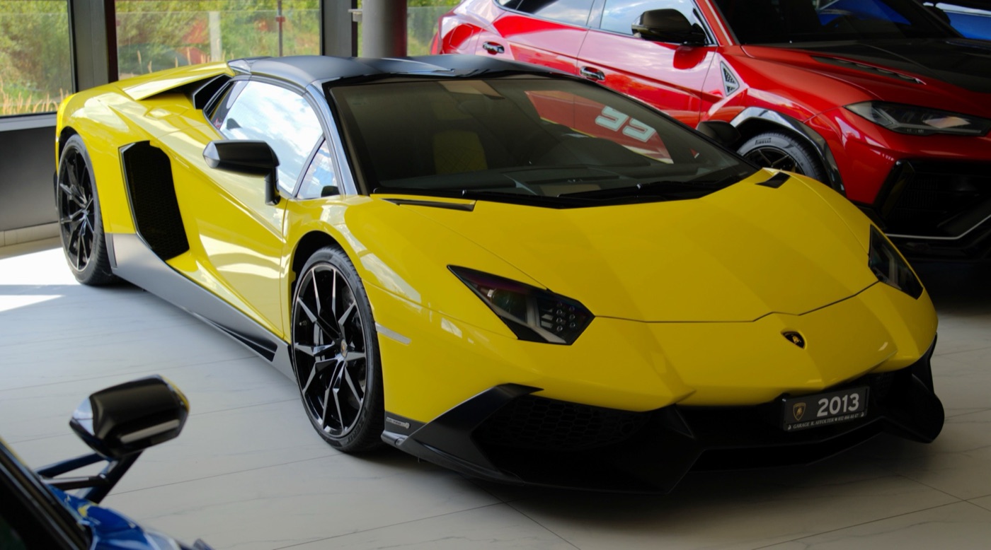 Yellow Lamborghini Aventador LP 720-4 50 Anniversario with black roof and grey sills in a dealer showroom
