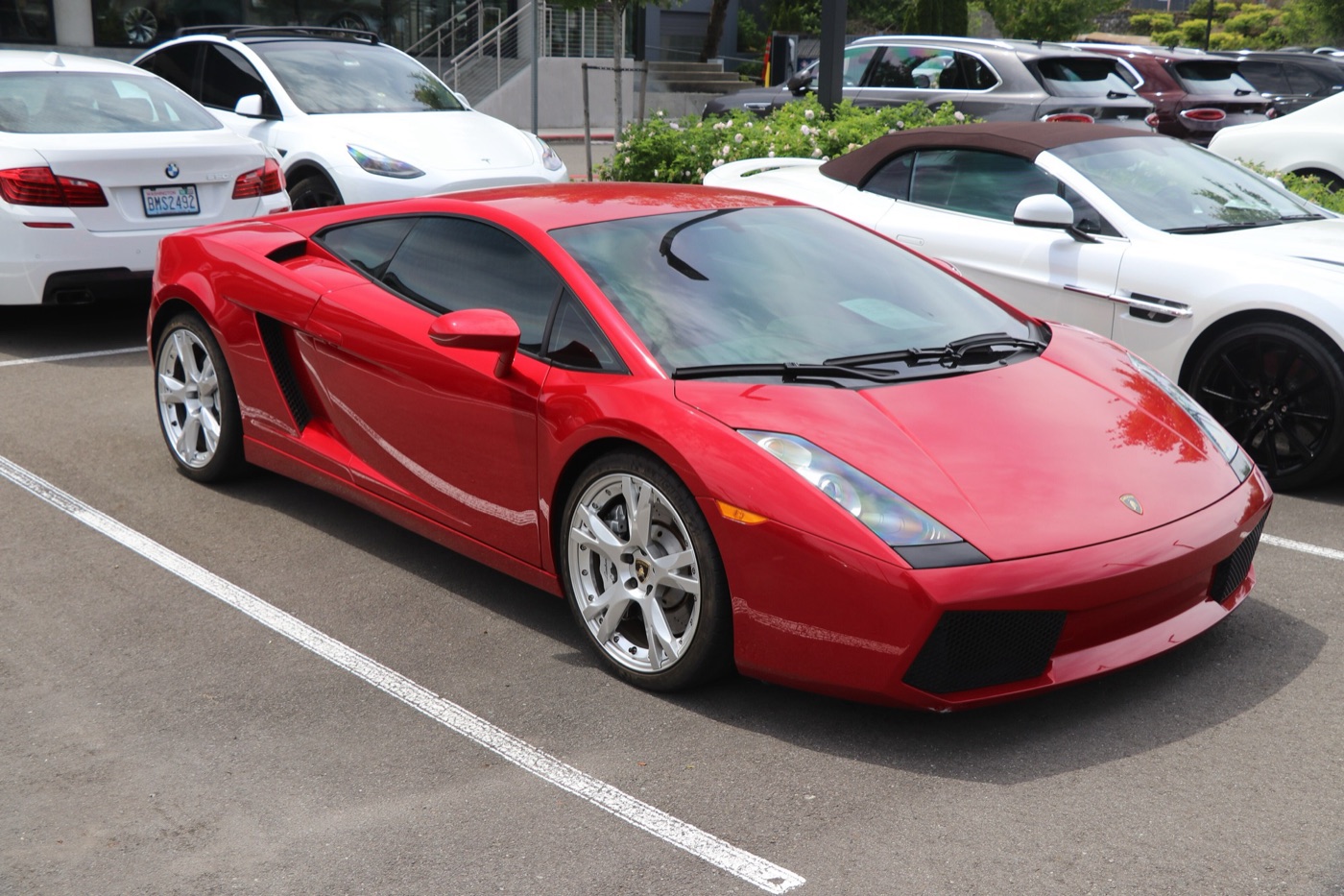 Red first-series Lamborghini Gallardo coupé with silver five-spoke wheels, parked in a car park