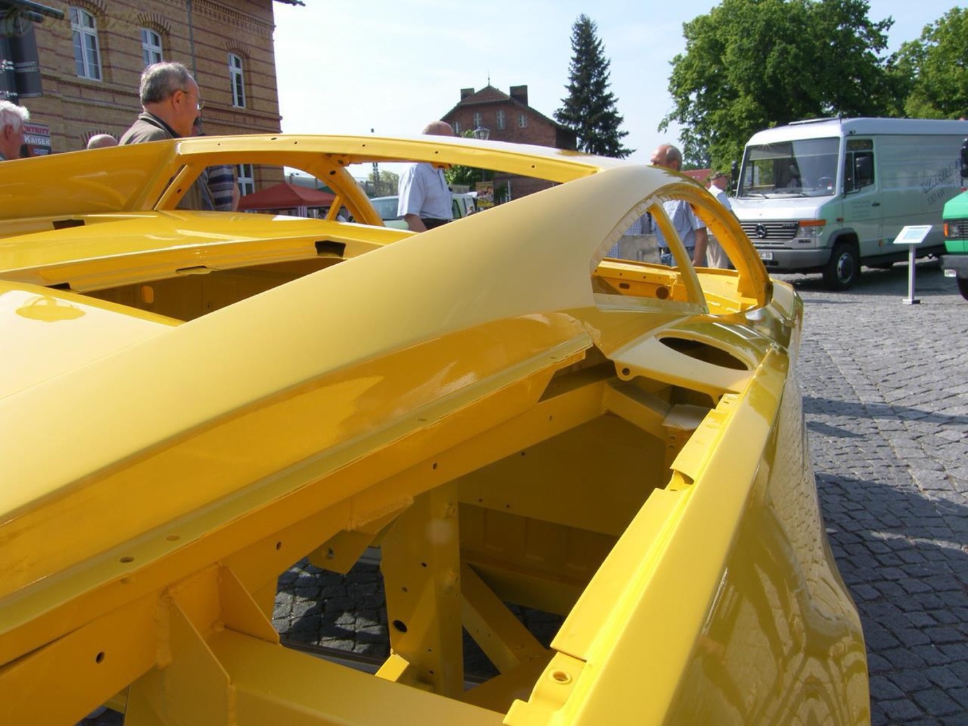 Yellow-painted Gallardo body shell with no glass, doors or mechanicals, showing the aluminium frame members inside