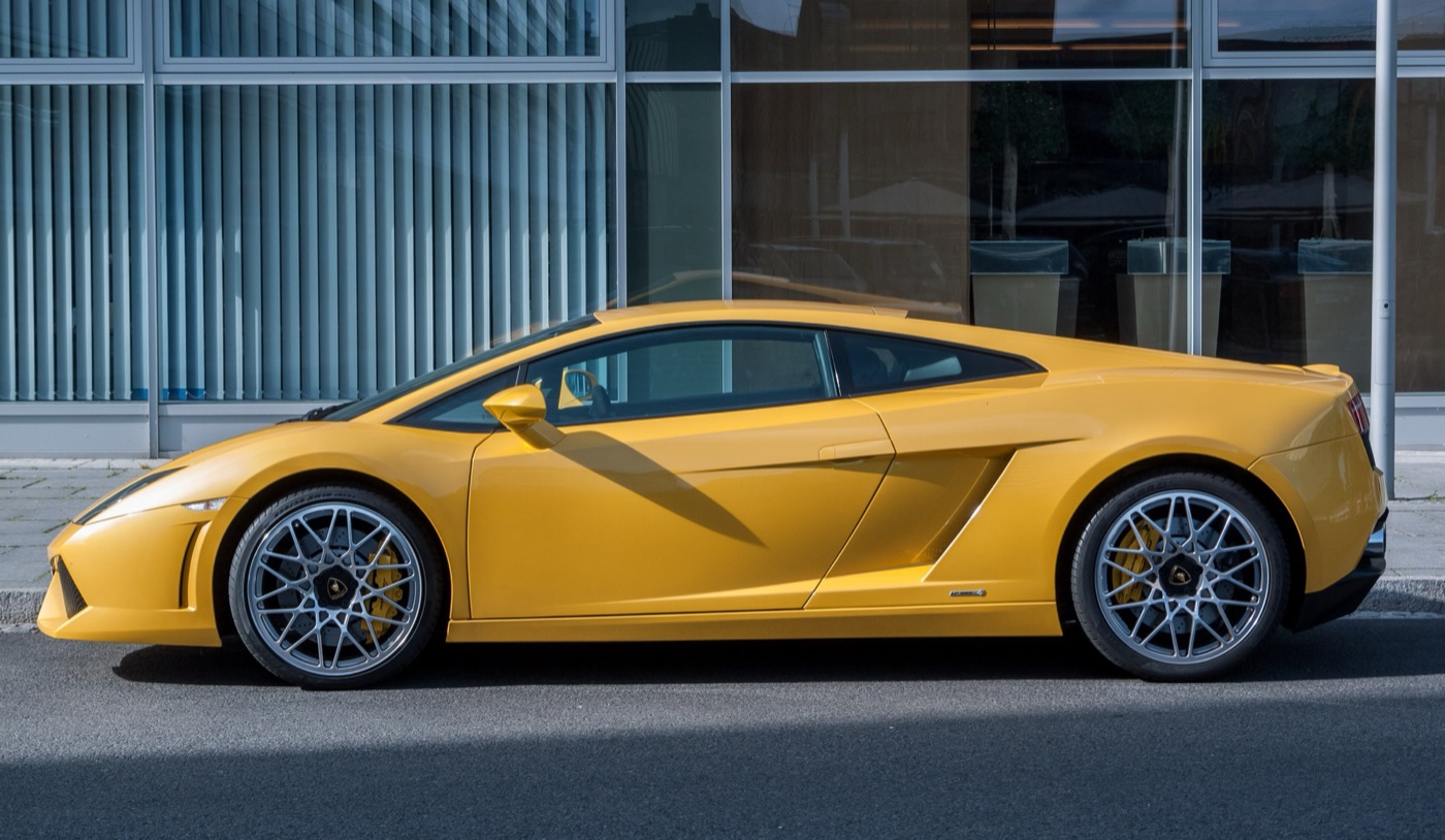 Yellow Lamborghini Gallardo LP 560-4 coupé in side view, parked beside a glass office building