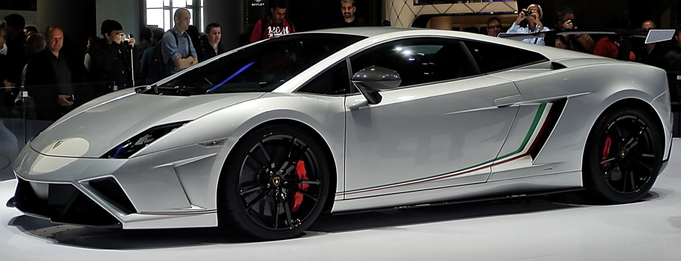 Silver Lamborghini Gallardo LP570-4 Squadra Corse with black wheels, red calipers and a tricolour stripe behind the door, on a motor show stand