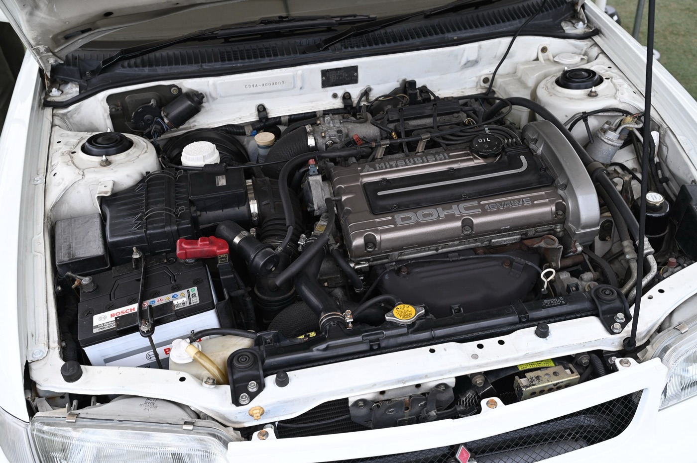The 4G63 twin-cam turbocharged engine in the bay of a 1992 Lancer GSR Evolution, with frame number CD9A-0000003 on the bulkhead