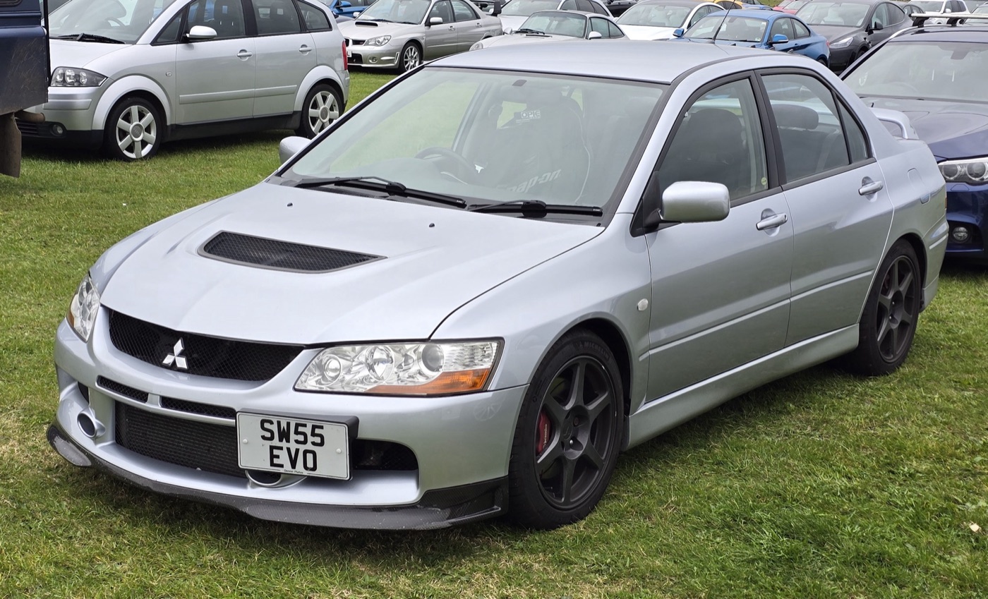 Silver 2005 Mitsubishi Lancer Evolution IX with a UK number plate on grass at a car show