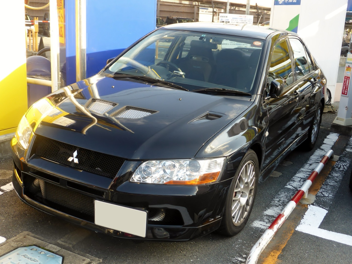 Black Mitsubishi Lancer Evolution VII parked at a car park in Japan, front three-quarter view