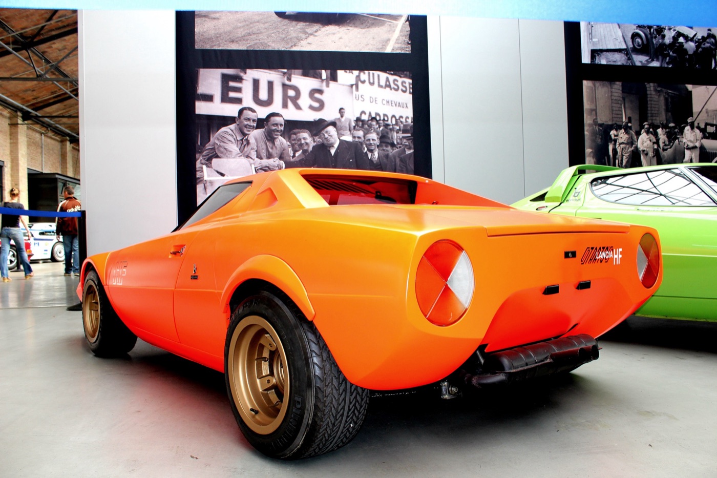 Orange Lancia Stratos HF prototype from behind, with round tail lamps, gold wheels and a short rear deck