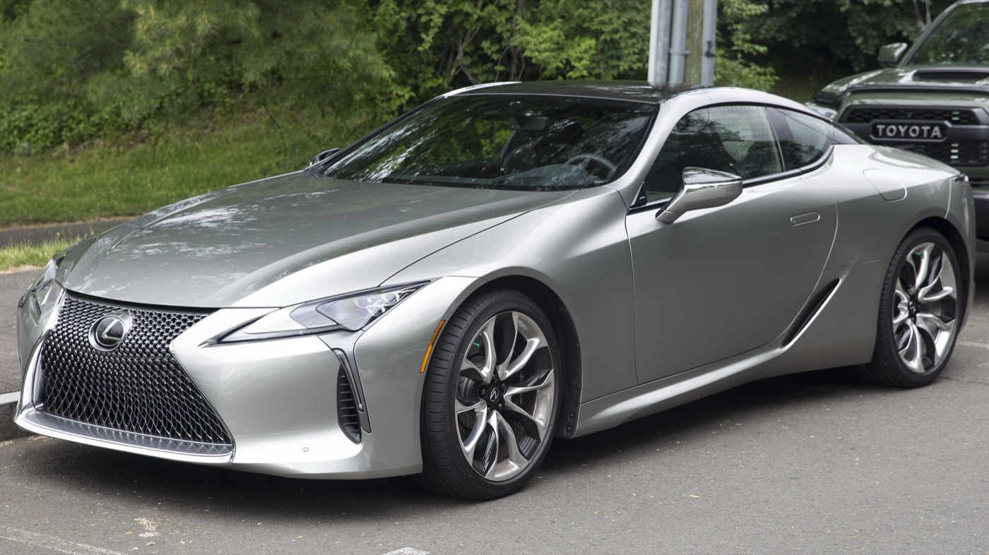 Silver Lexus LC 500 coupe seen from the front three-quarter, showing its mesh spindle grille and 21-inch wheels