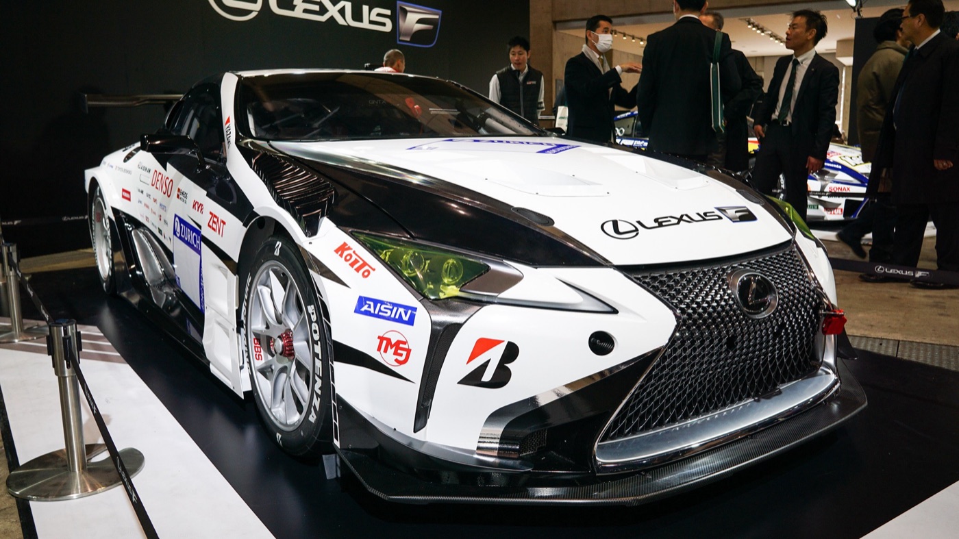 White and black Lexus LC race car with sponsor decals on display on the Toyota Gazoo Racing stand
