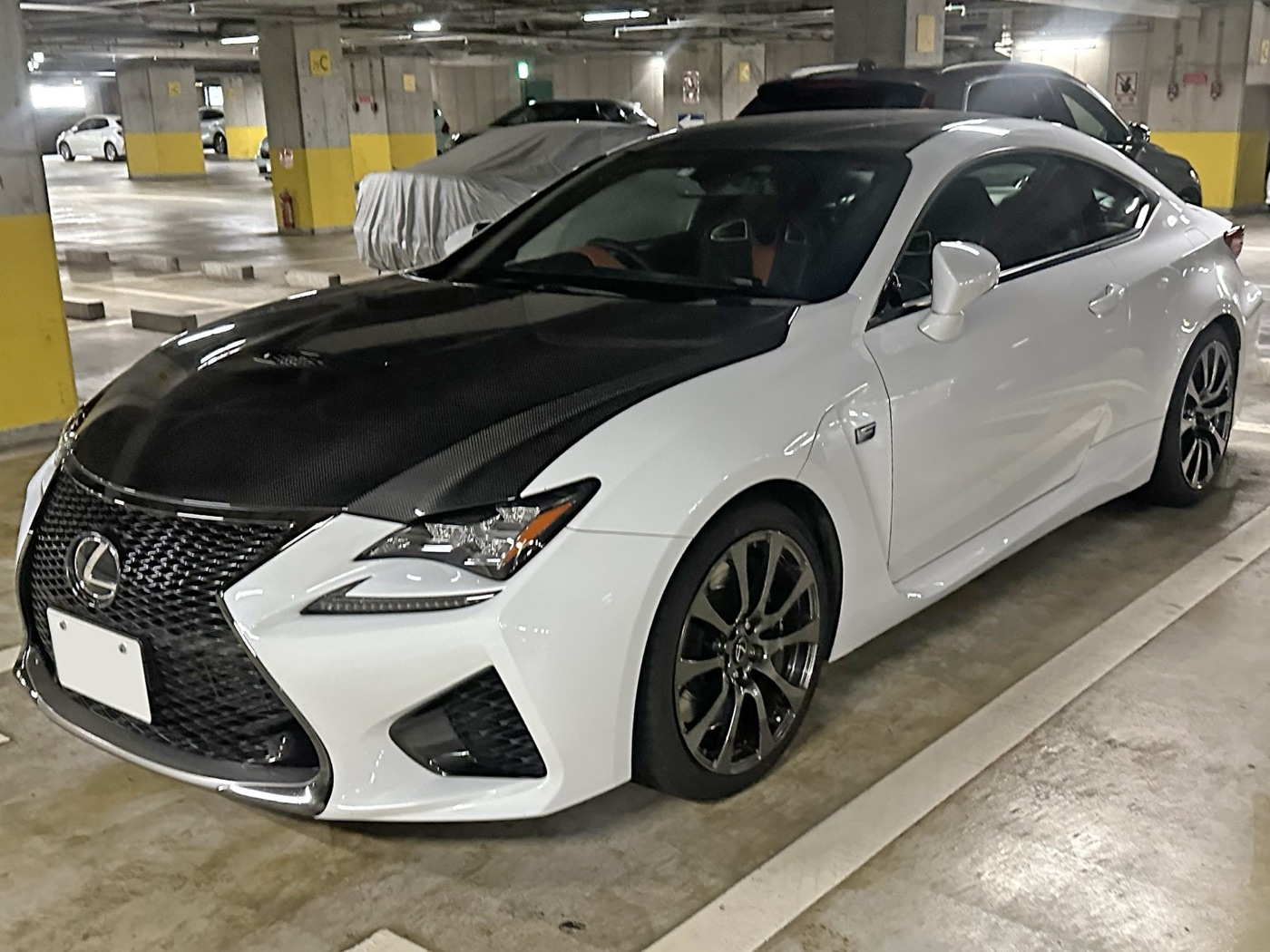 White Lexus RC F with a black carbon fibre bonnet and roof seen from the front