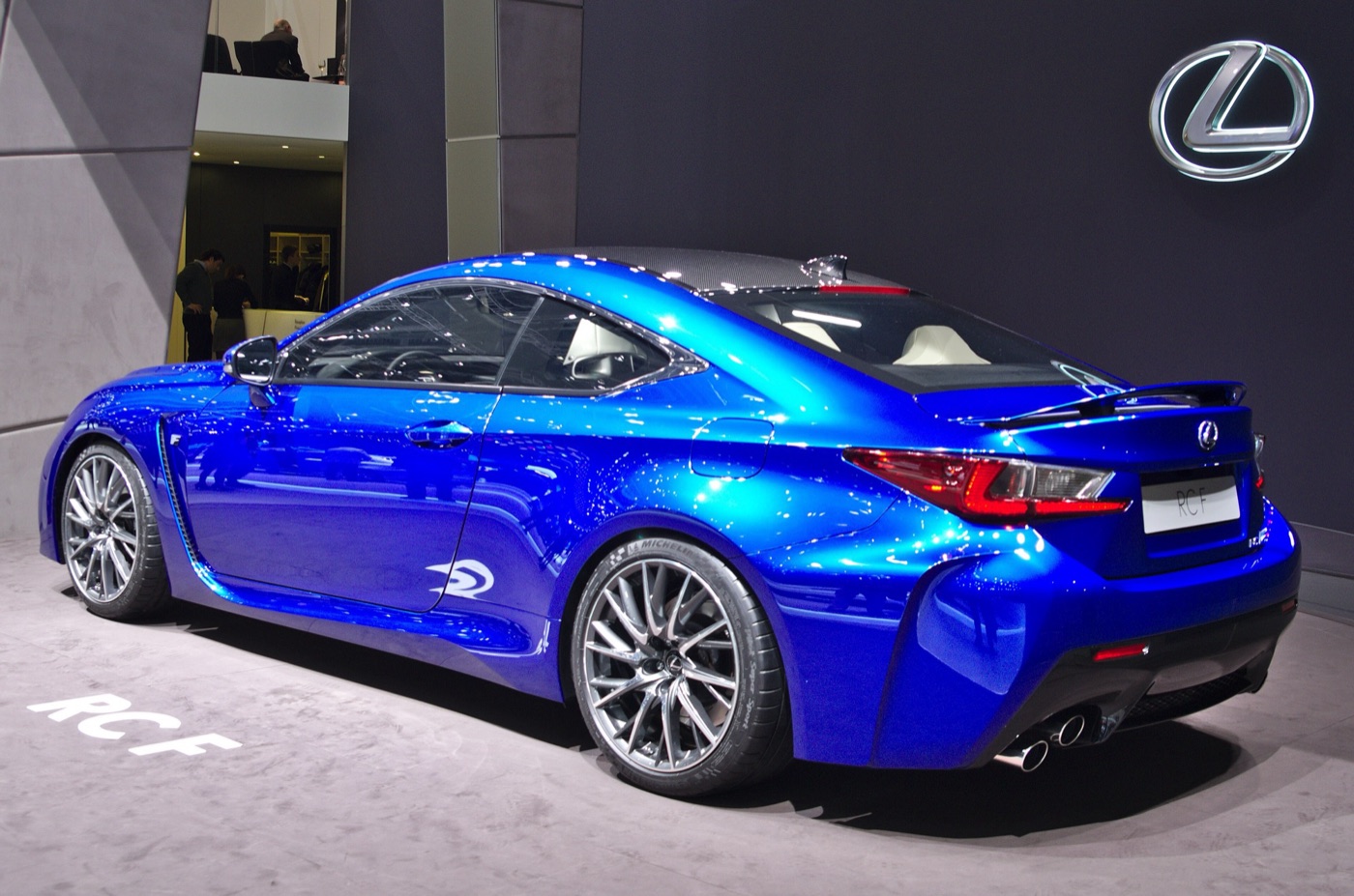 Blue Lexus RC F coupe seen from the rear three-quarter on the Lexus stand, showing its quad exhausts and raised rear wing