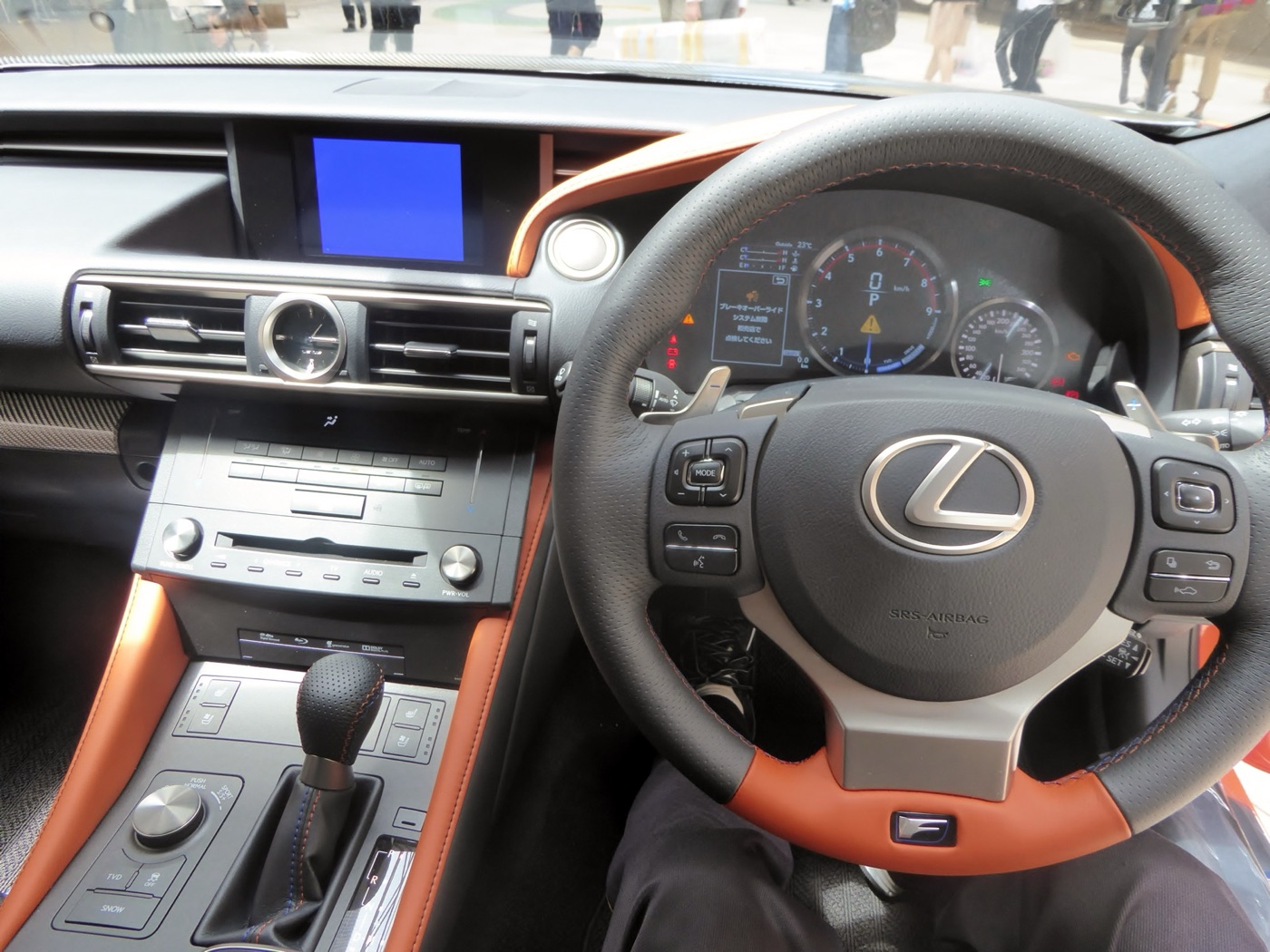 Right-hand-drive Lexus RC F dashboard with a thick-rimmed steering wheel, a large central rev counter and orange trim