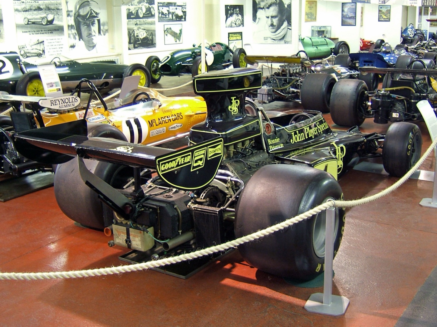 Rear three-quarter view of a black and gold John Player Special Lotus 72E with Ronnie Peterson