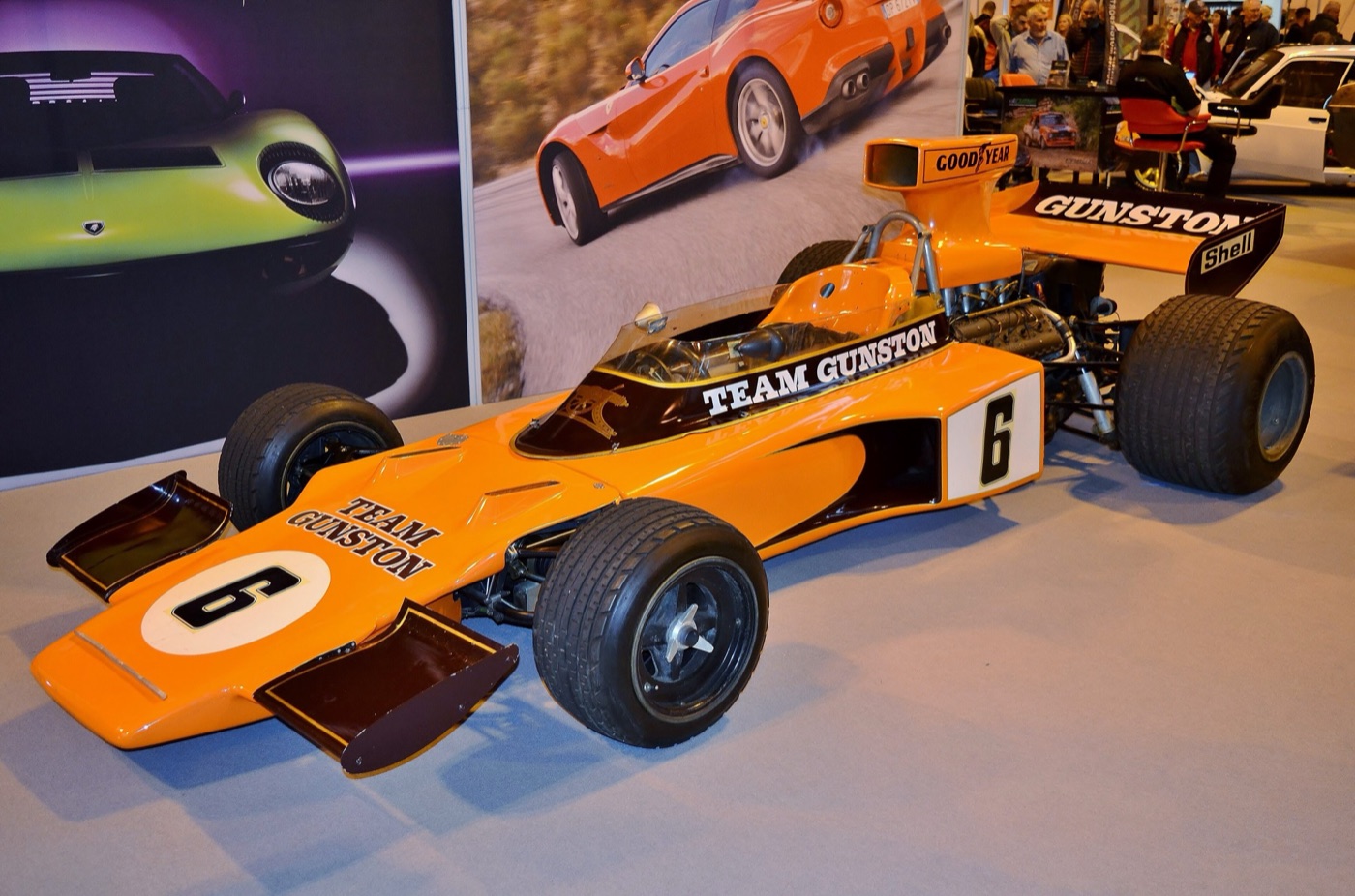 Orange and black Team Gunston Lotus 72D numbered 6 on display at an indoor motor show