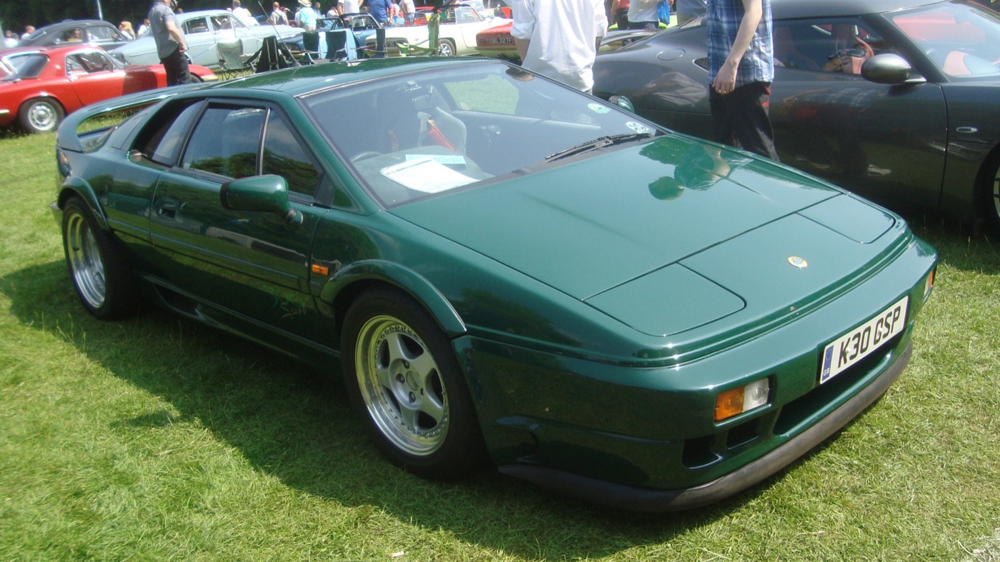 Green Lotus Esprit Sport 300 with five-spoke alloy wheels parked on grass at a show