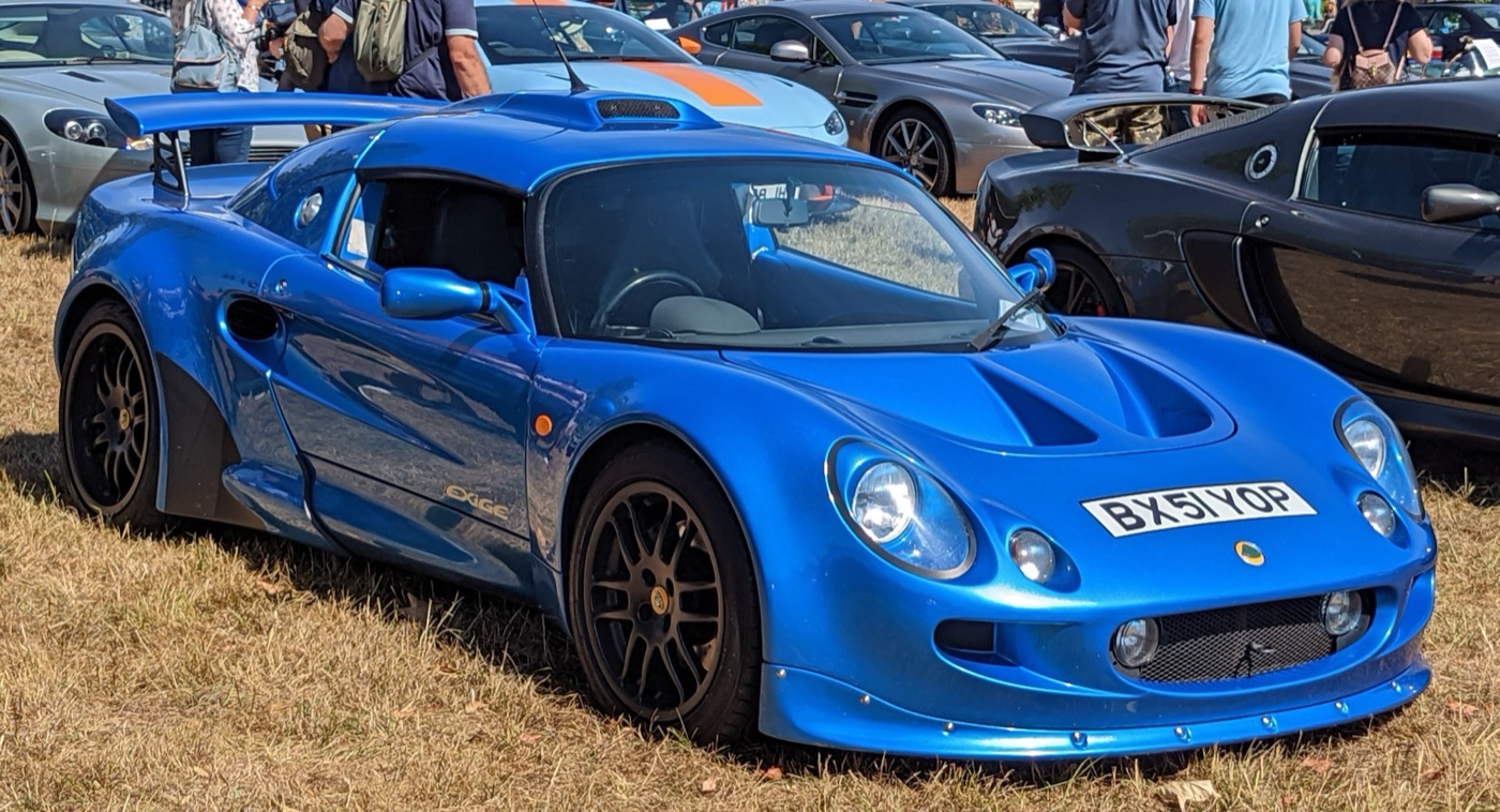 Blue Lotus Exige Series 1 coupé with roof scoop and fixed rear wing, parked on grass