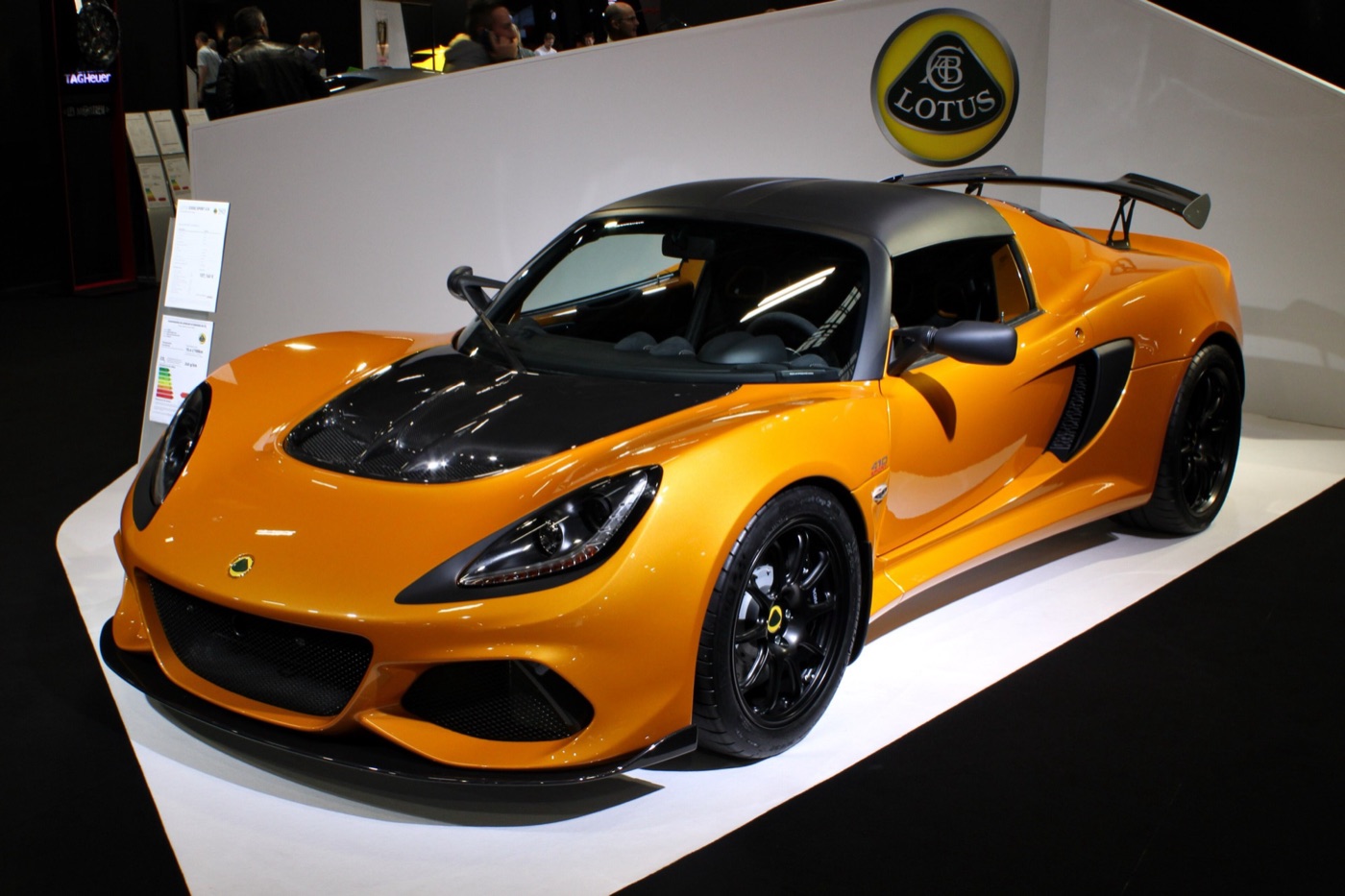 Orange Lotus Exige Sport 410 coupé with black roof and rear wing on the Lotus stand at a motor show