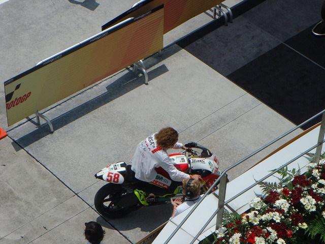 Marco Simoncelli, seen from above, riding his number 58 Gilera 250 into parc fermé at Sepang