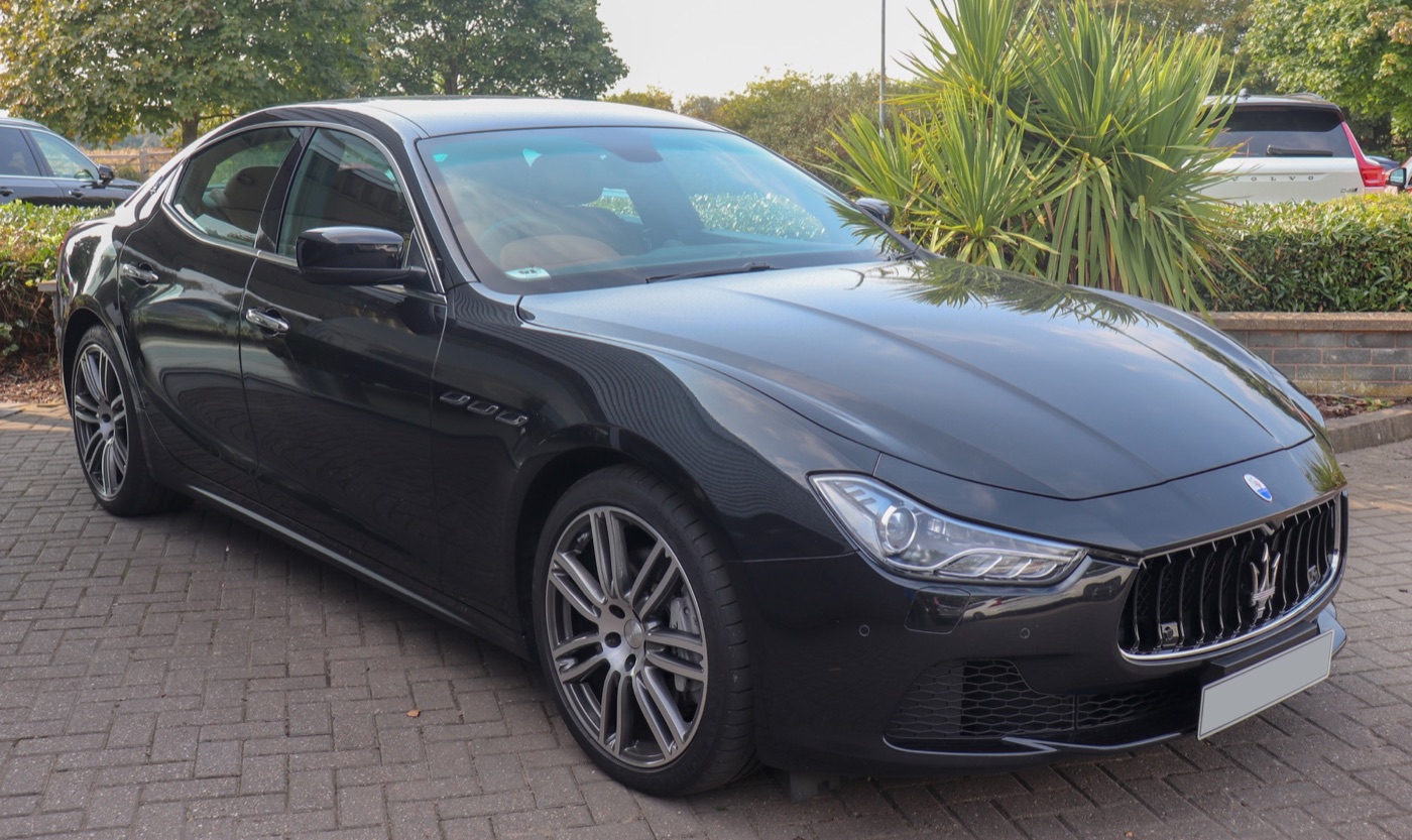 Black 2014 Maserati Ghibli diesel saloon parked on block paving, front three-quarter view with grey multi-spoke alloy wheels