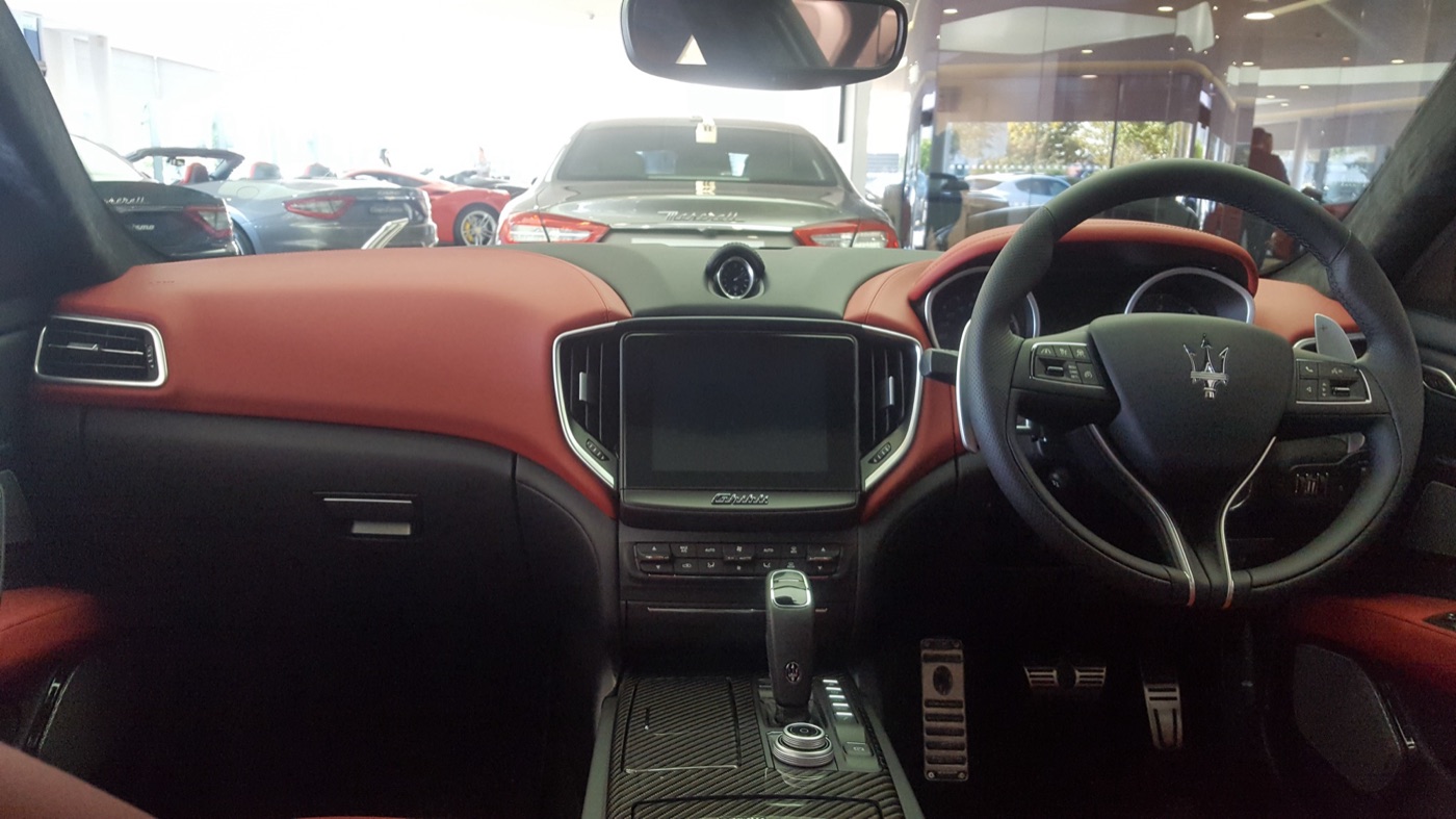 Right-hand-drive Maserati Ghibli GranSport dashboard with red leather, a central touchscreen, aluminium gearshift paddles and an automatic gear lever