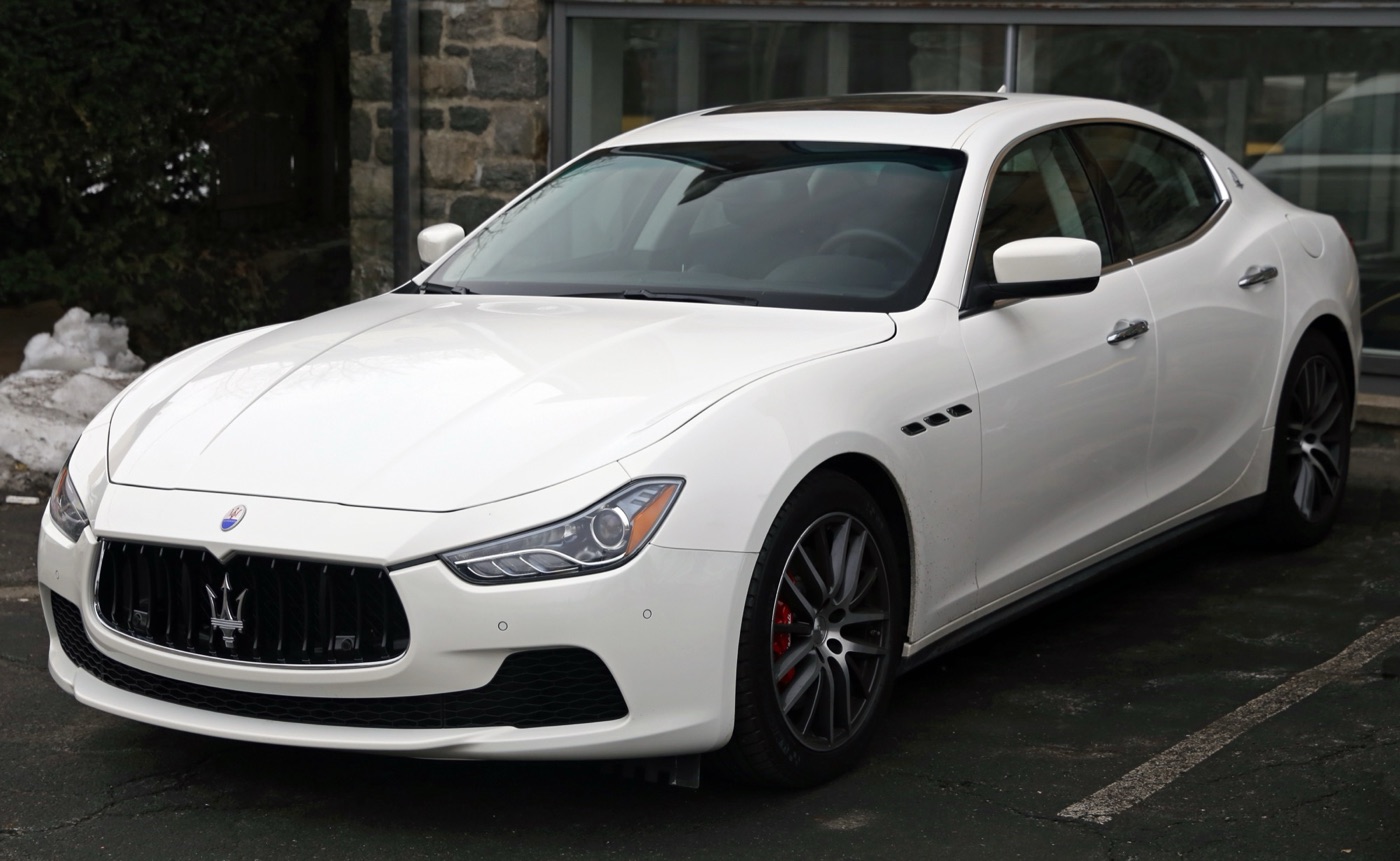 White 2014 Maserati Ghibli S Q4 saloon seen from the front left, with red brake calipers and three air vents on the front wing