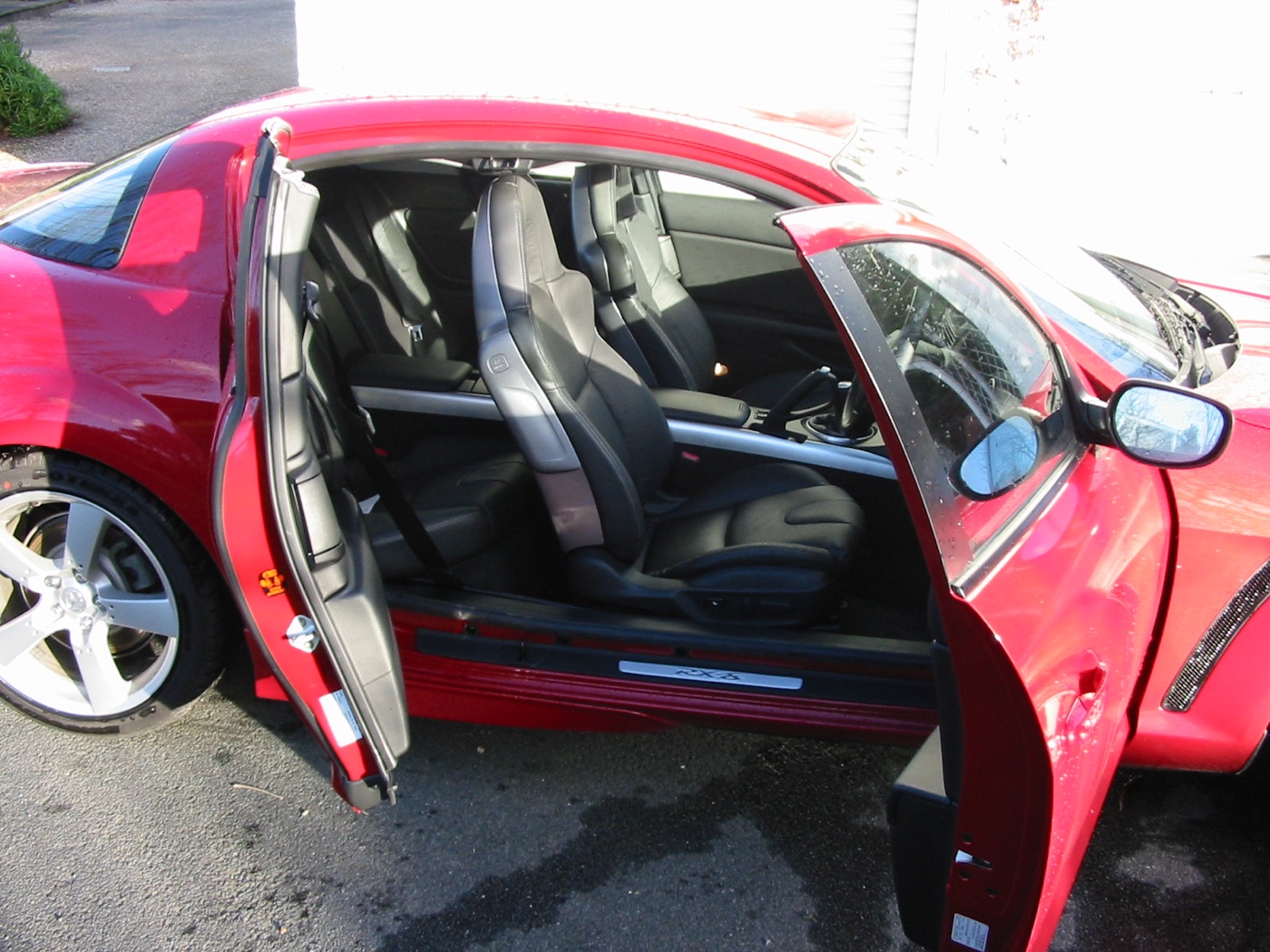 Red Mazda RX-8 with its front door and rear-hinged rear door both open, showing the opening with no pillar between them