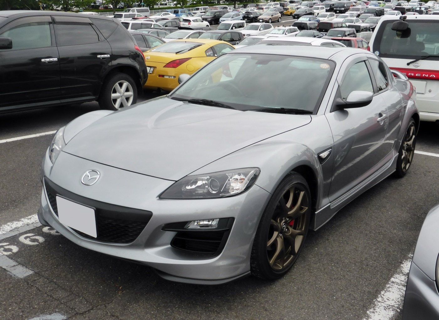 Silver Mazda RX-8 Spirit R with bronze five-spoke wheels and red brake calipers in a car park